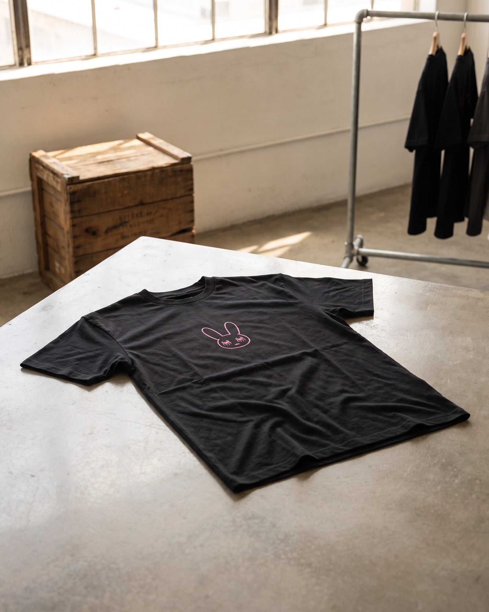 Camiseta SOBETEO SPIDER negra doblada sobre una mesa de madera, vista por la espalda